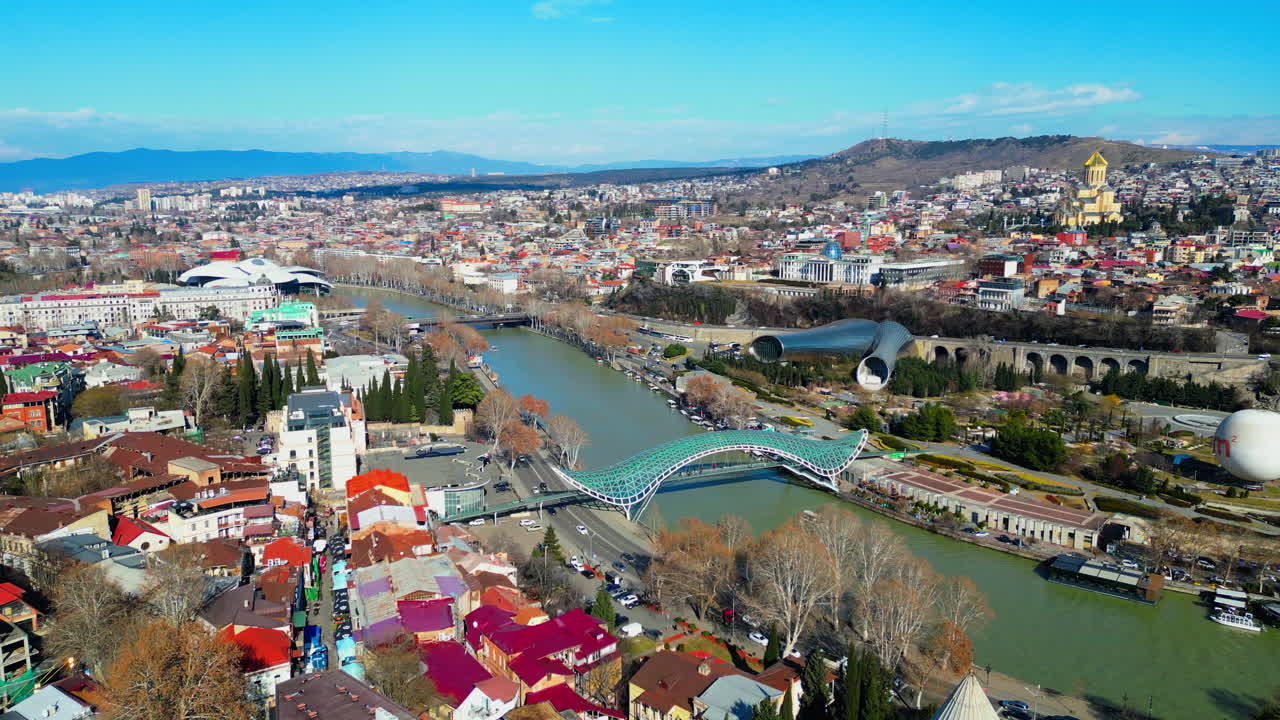 Filmové záběry dronu v rozlišení 4K letícího nad Mostem míru v Tbilisi, odhalujícího elegantní architektonický design klenoucí se přes řeku Kura_45.