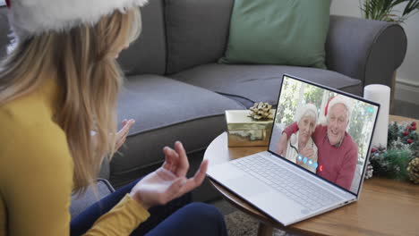 feliz hija caucásica y padres mayores teniendo navidad llamada de video portátil, cámara lenta