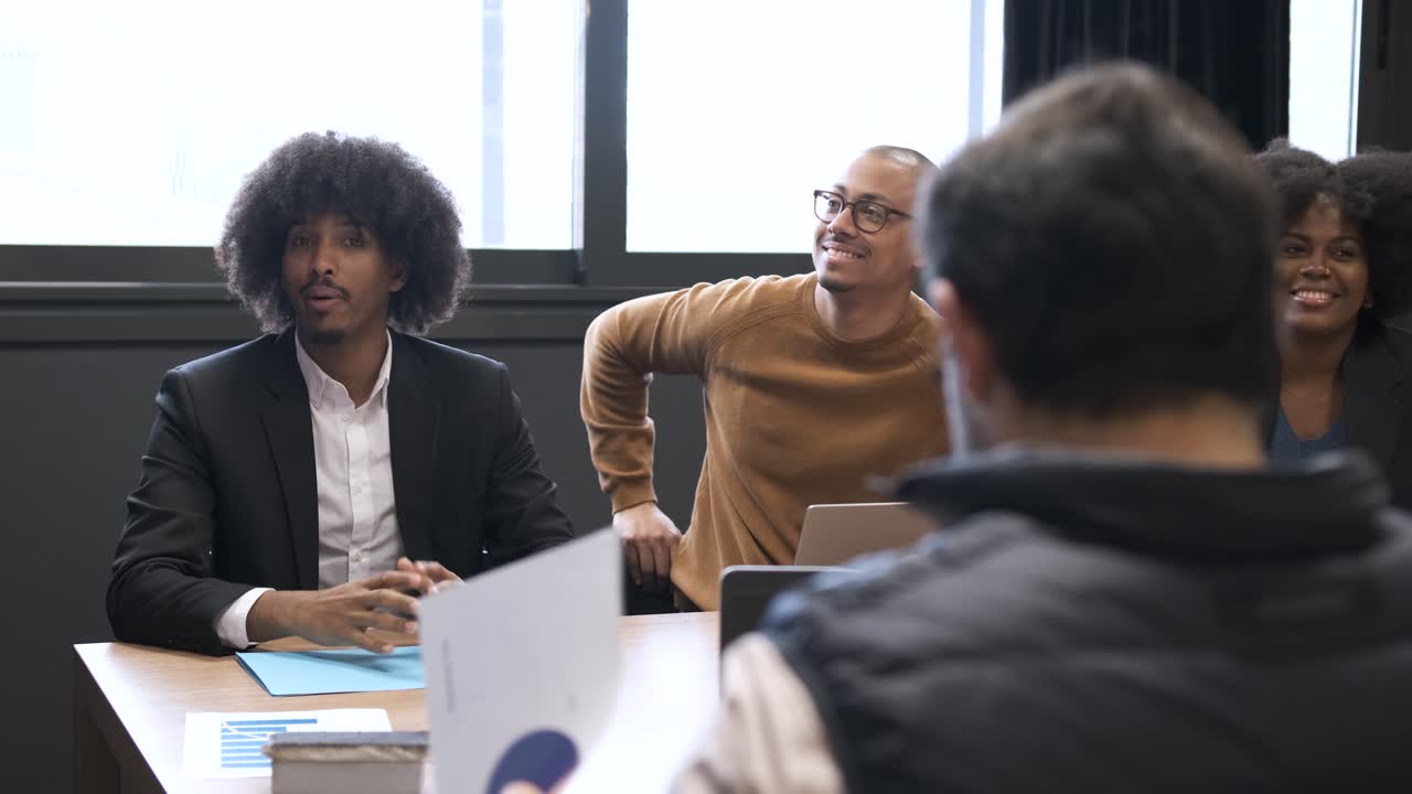 Pengusaha multietnis bahagia bertepuk tangan saat presentasi di kantor.