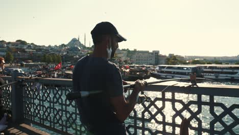 istanbul jul 26, 2021 rear view peaceful young fisherman using spinning fishing rod on summer sunset near hagia sophia.