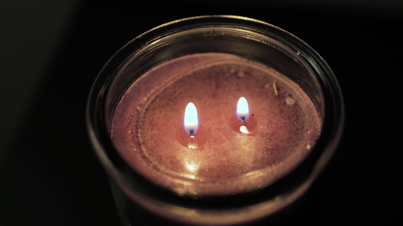 Candela con due fiamme e due stoppini vista dall'alto