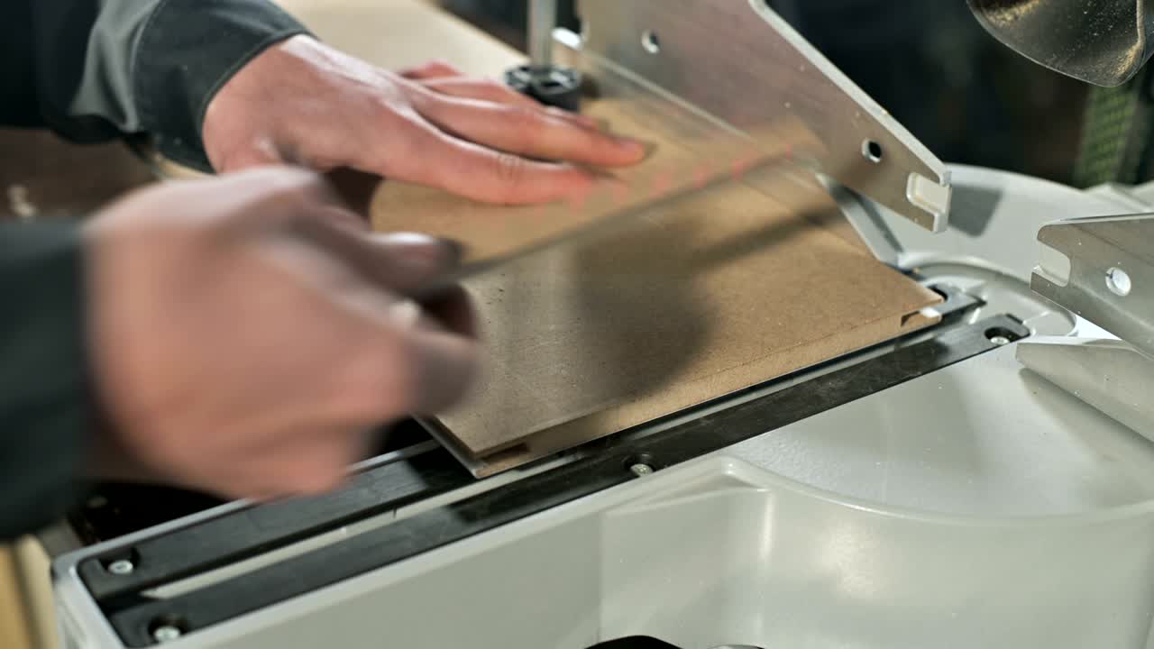 primer plano de la mano de un hombre trabajando en una máquina con una sierra circular