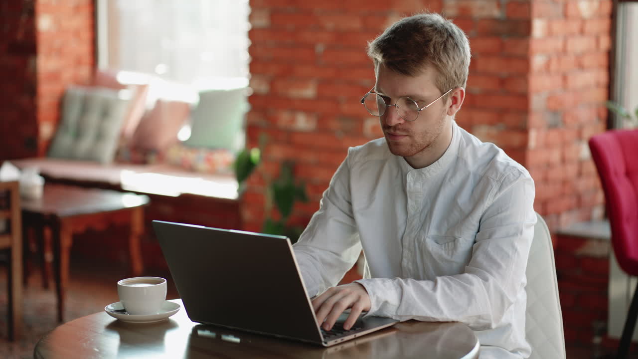 hombre de negocios o especialista financiero independiente está trabajando con una computadora portátil en un café escribiendo mensajes y enviando correos electrónicos