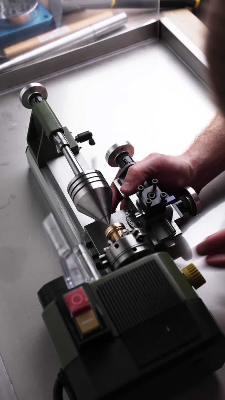 Hands Operating a Mini Lathe Machine in a Workshop