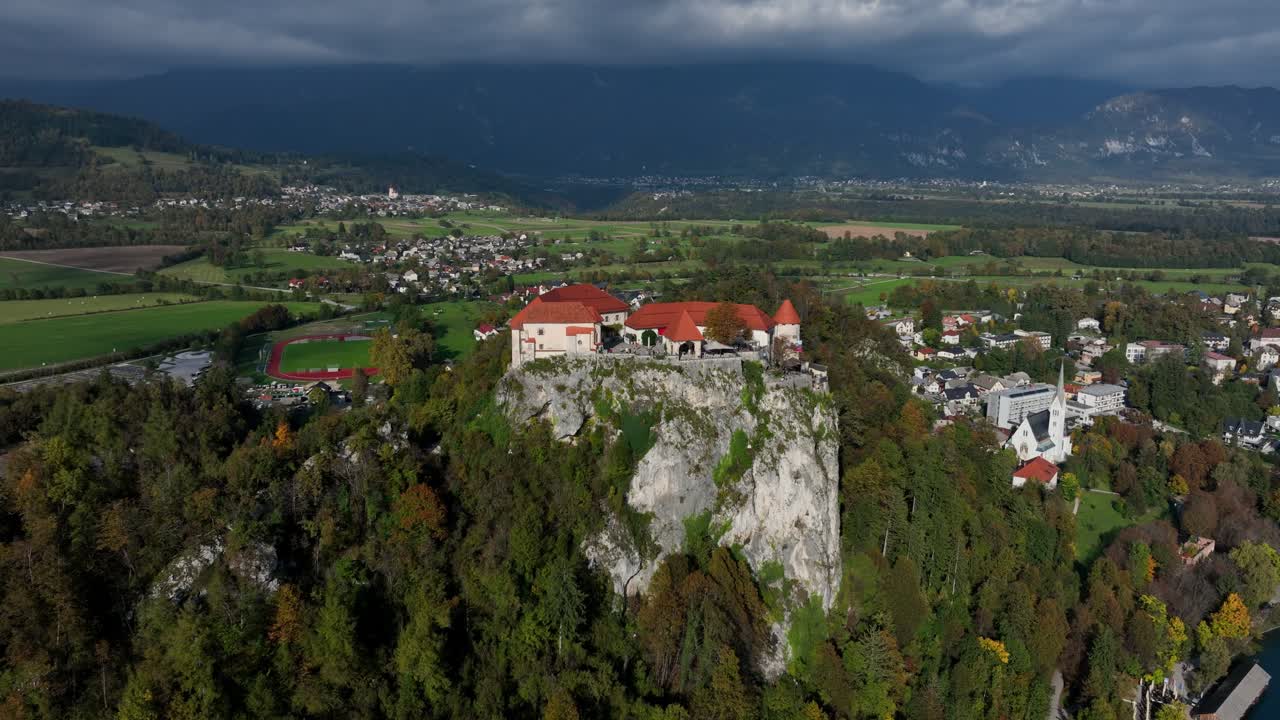 Splendide riprese aeree con drone dello storico Castello di Bled, arroccato in alto su una ripida scogliera che domina il bellissimo Lago di Bled e la città circostante in Slovenia