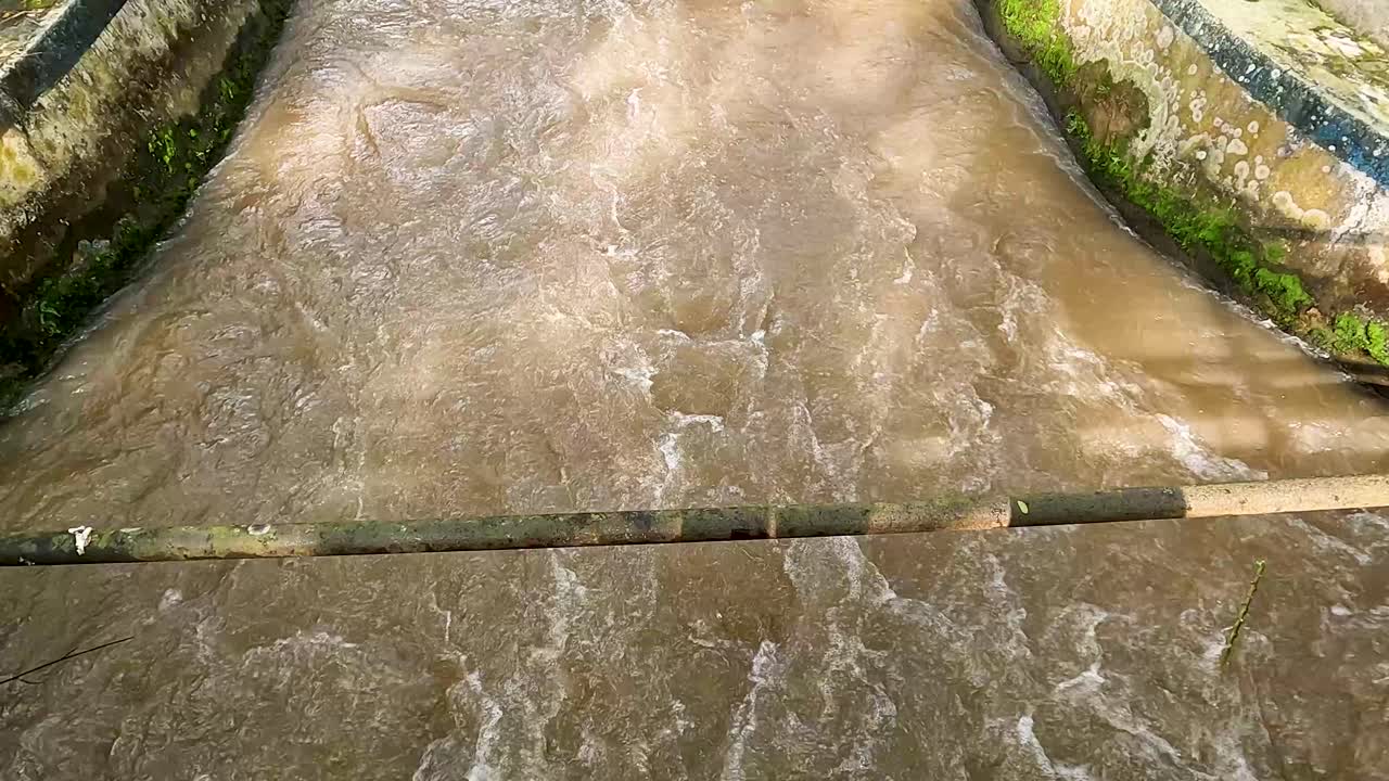 Static view of brown water flowing rapidly in Manggis river, Indonesia