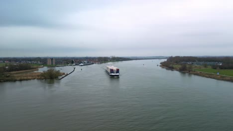 Aerial-view:-Cargo-ship-with-containers-moving-through-the-canal-"Oude-Maas"-in-Zwijndrecht,-The-Netherlands