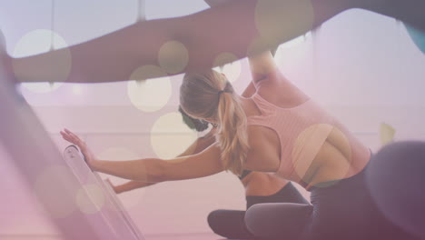people stretching in yoga class with bokeh lights animation overlay