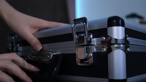 hand opening a black and silver briefcase