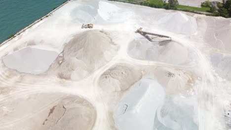 drone footage of construction vehicle moving aggregates in windsor ontario industrial zone