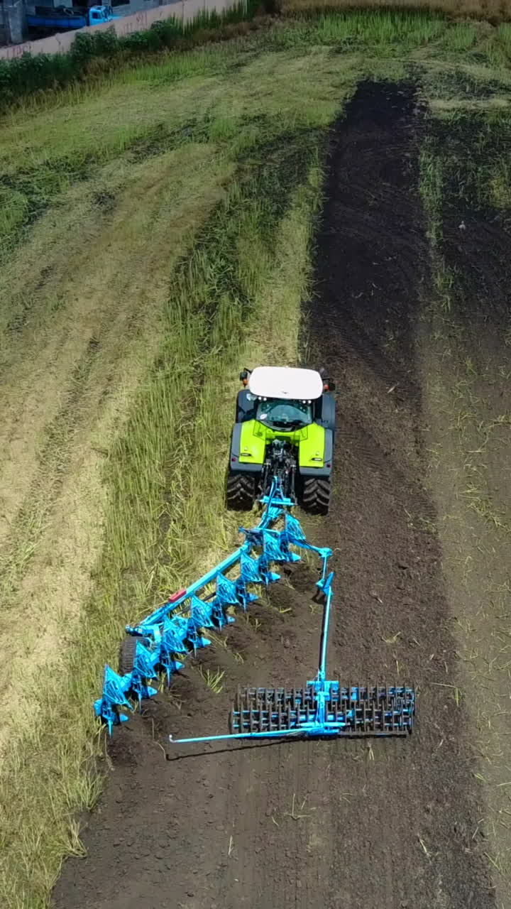 Tractor Plows The Field. Tractor with cultivator handles field before planting Vertical video