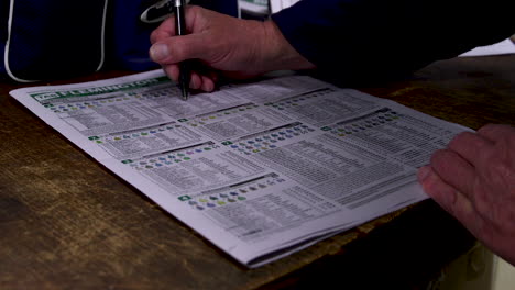 Placing or marking bets on a racing guide newspaper