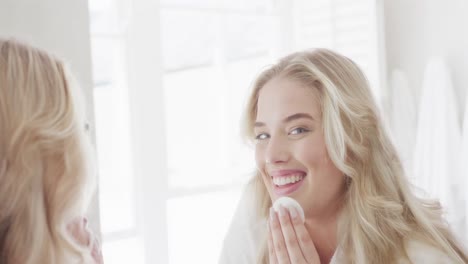 portrait of happy caucasian plus size woman in front of mirror doing make up in slow motion