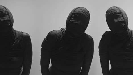 mummies on a white backdrop move their heads