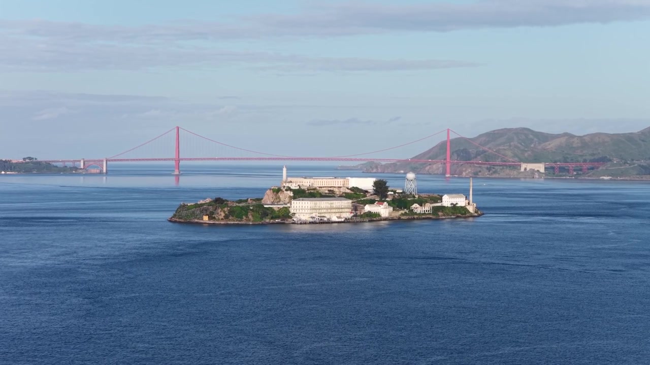 Đảo Alcatraz với các tòa nhà nhà tù lịch sử và tháp nước trong Vịnh San Francisco, cùng Cầu Cổng Vàng và Marin Headlands ở phía sau. Toàn cảnh nhìn từ trên cao bằng drone. Hòn đảo nổi tiếng ở Mỹ.