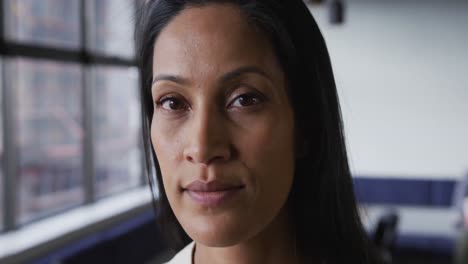 portrait close up of mixed race businesswoman looking at camera and smiling in office