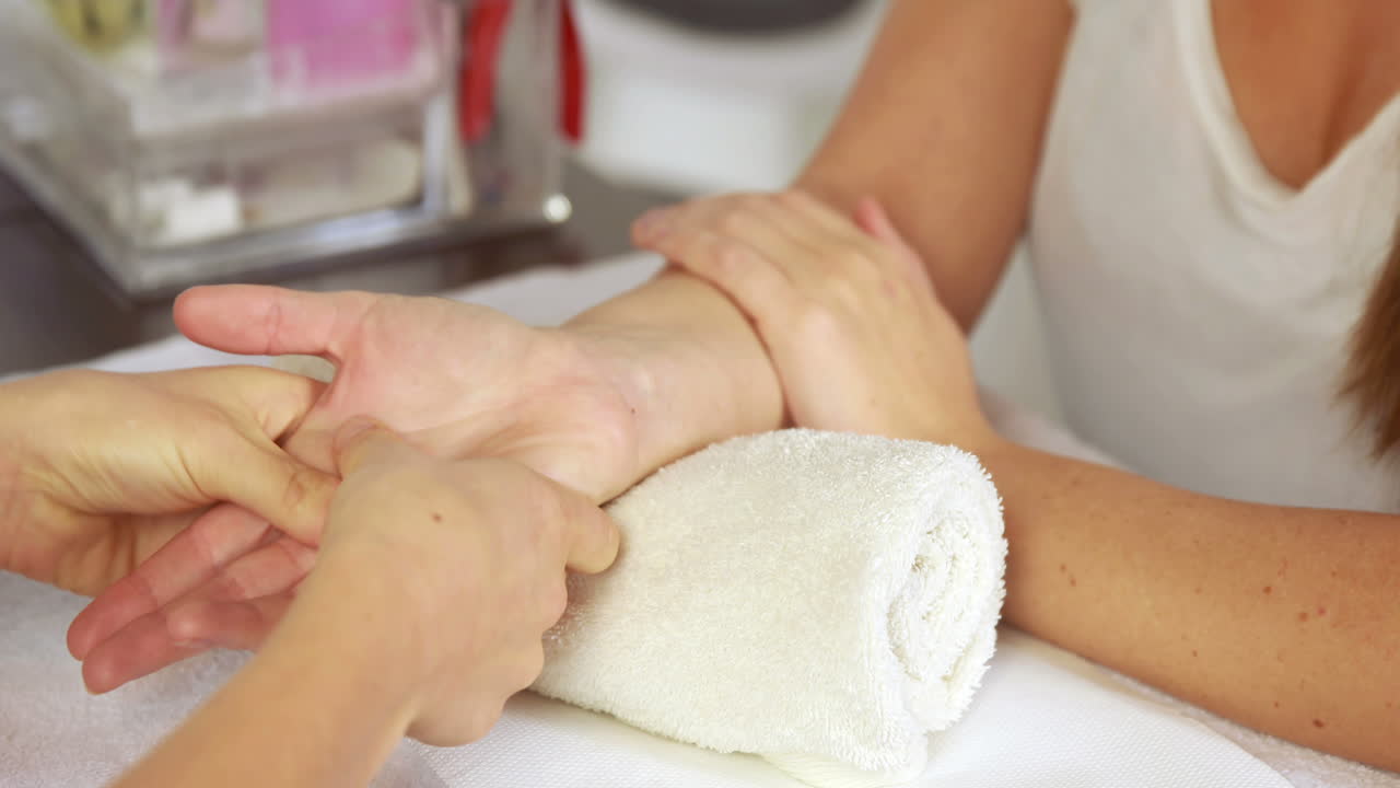 terapeuta de belleza masajeando la mano de los clientes