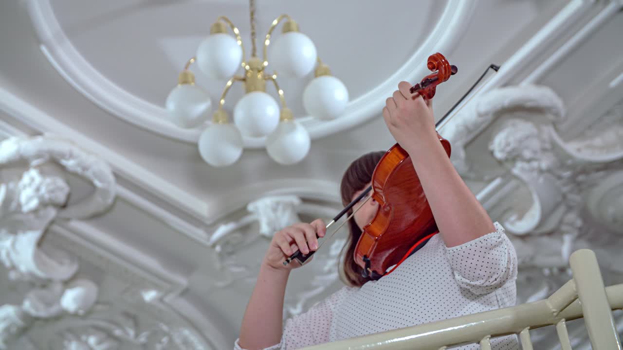 Young Caucasian woman plays violin, slow motion portrait