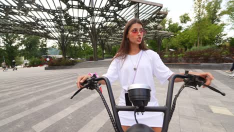 teenage girl riding an electric scooter in a park