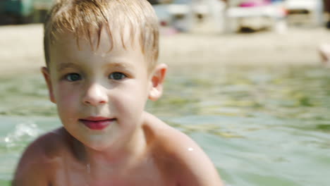 little boy swimming on board near the shore