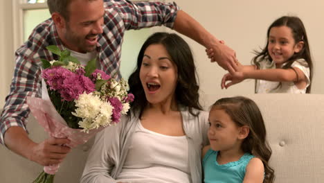 father and daughter giving bouquet to mother