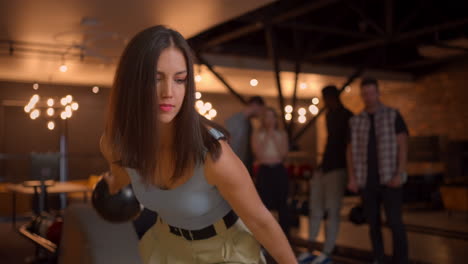 portert a brunette woman throwing a bowling ball and knocking out a winning shoot and dancing with happiness and joy