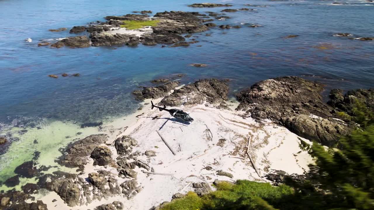 Rotating drone shot of helicopter on offshore island through the trees
