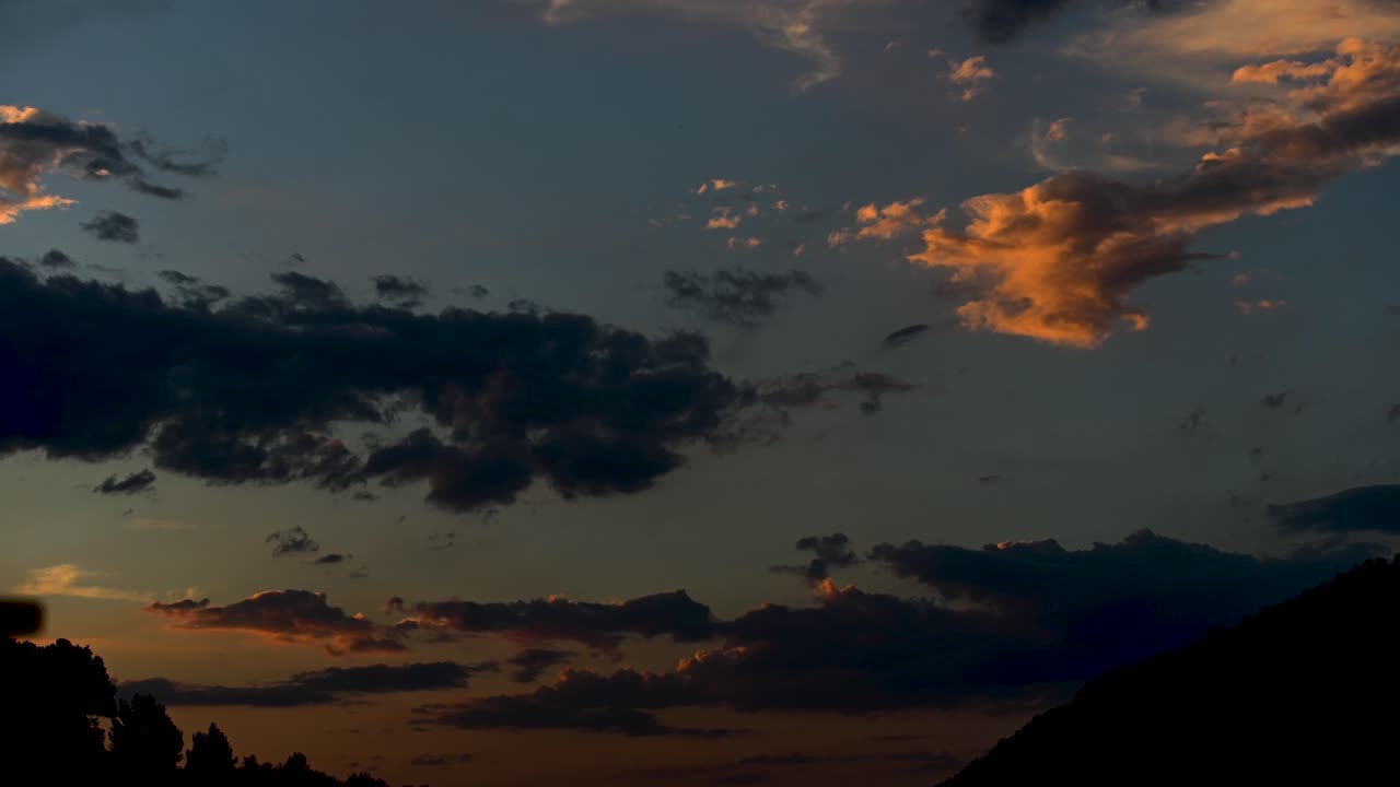 Atardecer colorido, time-lapse 4K con rápido movimiento de nubes y desvaneciéndose en la oscuridad.