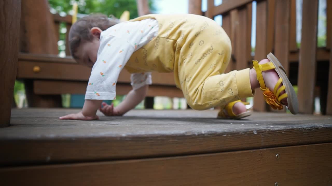 Eurasian Baby Girl Climb And Crawl On Stairs At Playground. - close up, behind