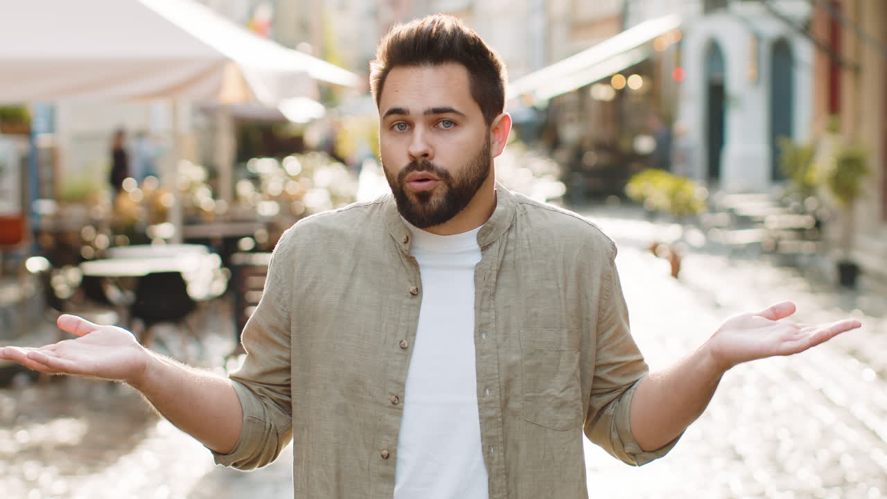 Confused man feeling embarrassed about ambiguous question having doubts no idea in city street