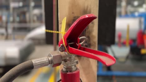 fire extinguisher on the industry production plant with blurry worker background