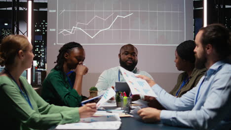 diverse employees discuss project details and forecast information