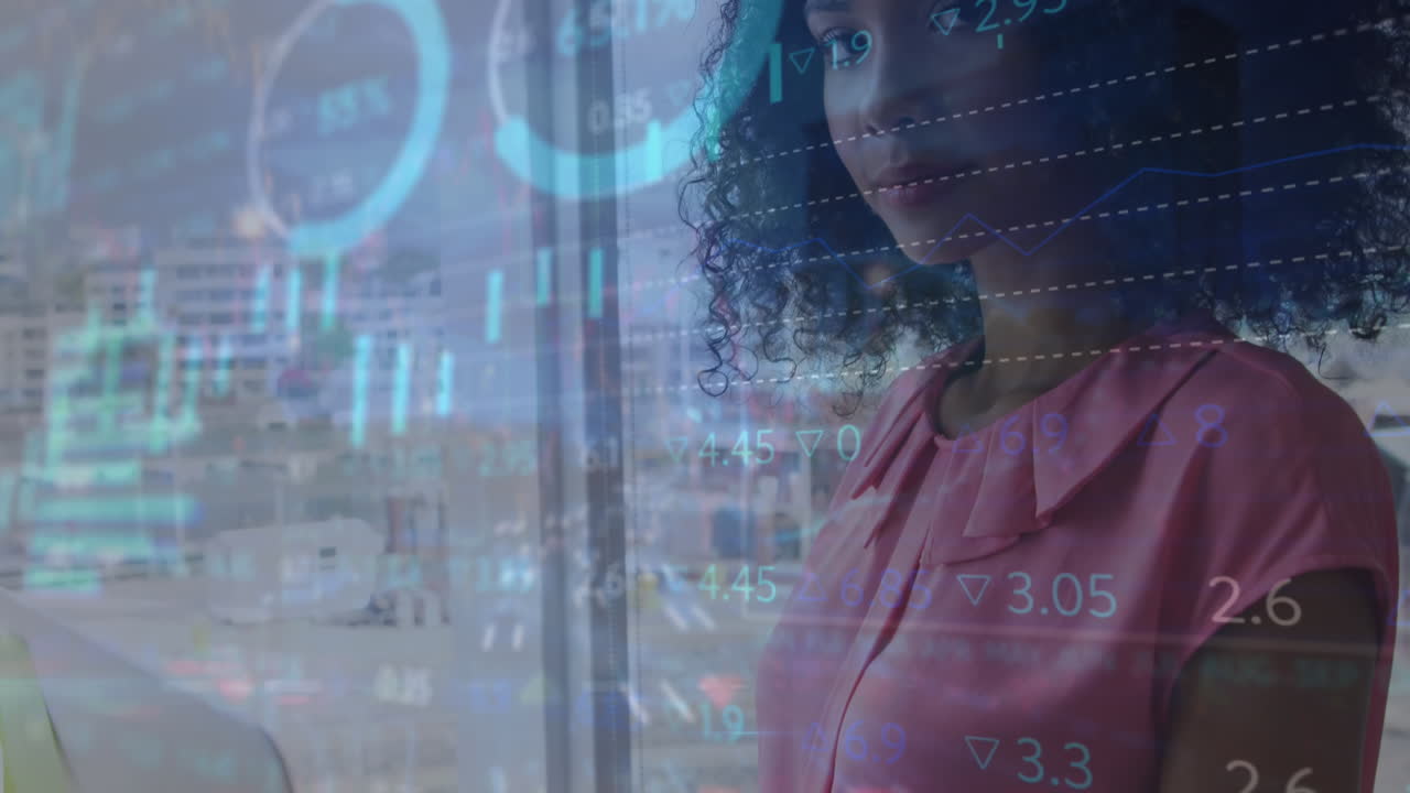 animación de múltiples gráficos y tablero de negociación sobre mujer biracial de pie y trabajando en la computadora portátil