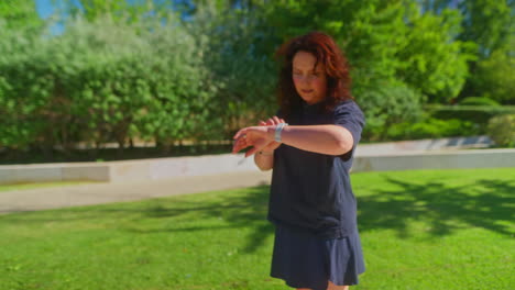 mujer comprobando el reloj inteligente en el parque