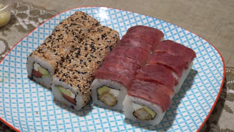 primer plano de varias piezas de makis california y tiradito rocoto en un plato en 4k