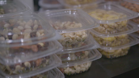 close up pan right of a pile of nut and snack packages