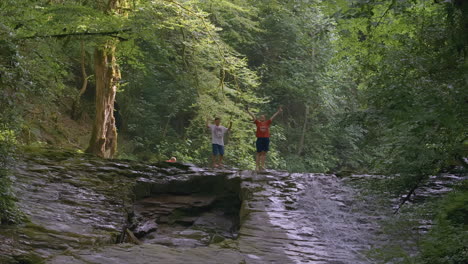 niños jugando en una cascada en el bosque