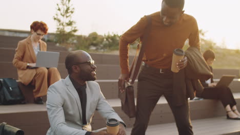 african american businessmen shaking hands and talking in park