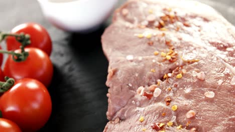 Sirloin-chop,-cherry-tomatoes-and-coriander-seeds-on-chopping-board