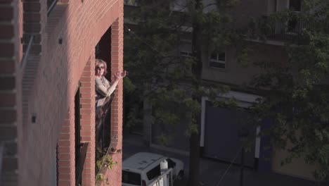 woman on balcony applauding