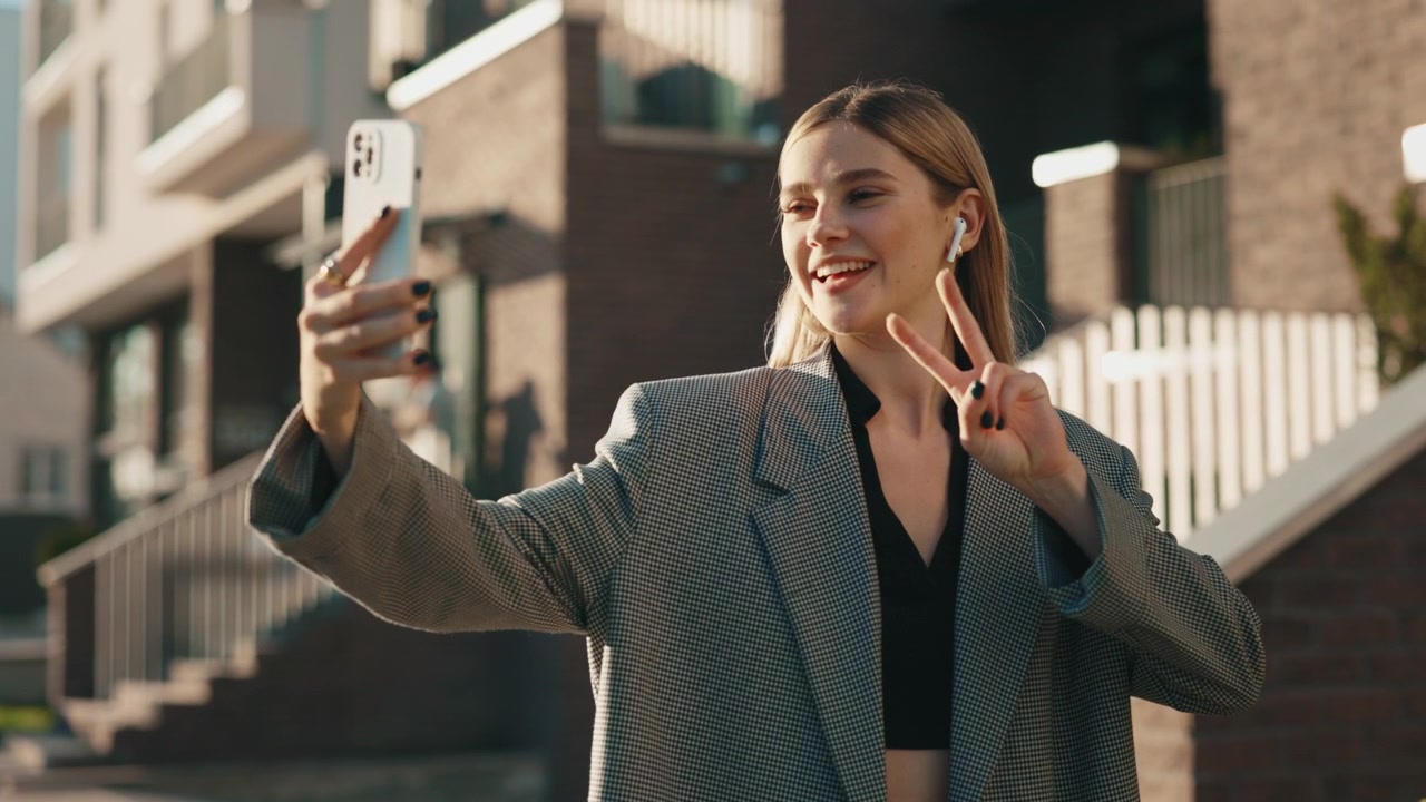 Young Woman Taking a Selfie and Using Her Smartphone Outdoors