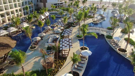 luxury swimming pool area in romantic vacation resort in punta cana, dominican republic, aerial view of vibrant longes and hotel area