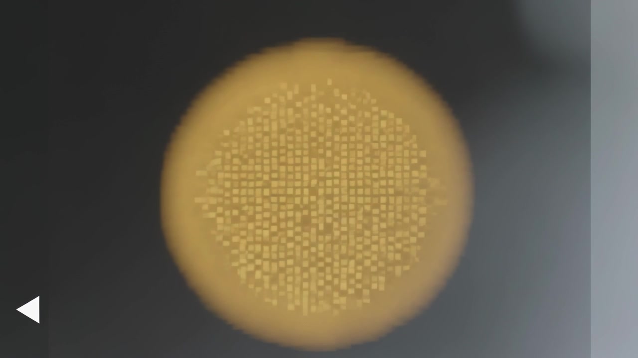Mostra un disco ambra centrale frame3 che rivela una griglia sfumata su schermo scuro, con un triangolo a sinistra e una banda grigia a destra.