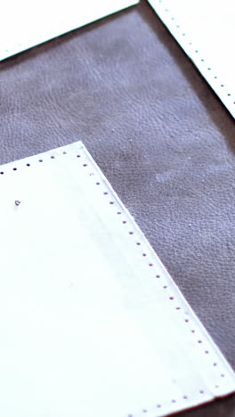 craftswoman arranging leather piece on work tool