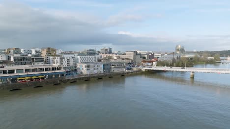 delmas bridge at garonne river shore near bassins à flots city area and cap science museum, aerial approach shot