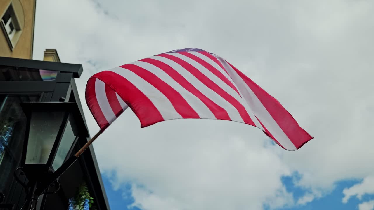 USA flag waves slowly in wind showing texture dirt marks and cloudy daylight