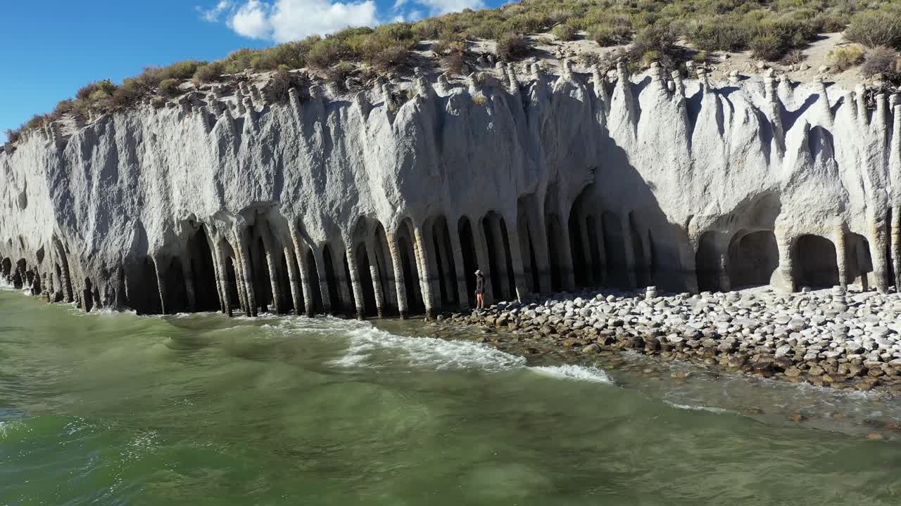 화창한 날 크롤리 호수 옆에 서 있는 외로운 여성 인물과 화창한 날 이상한 기둥의 공중 전망, 캘리포니아 미국, 드론 샷