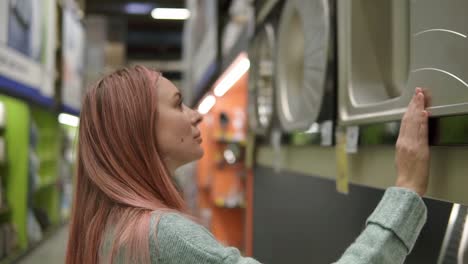 femme choisit et touche un nouvel évier de cuisine dans un magasin