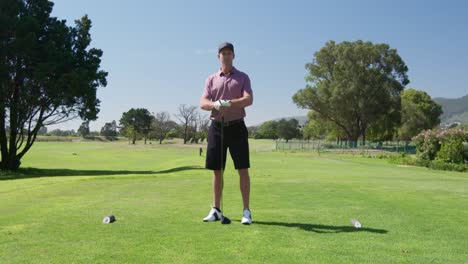 Caucasian-male-golfer-smiling-at-camera-on-a-golf-course