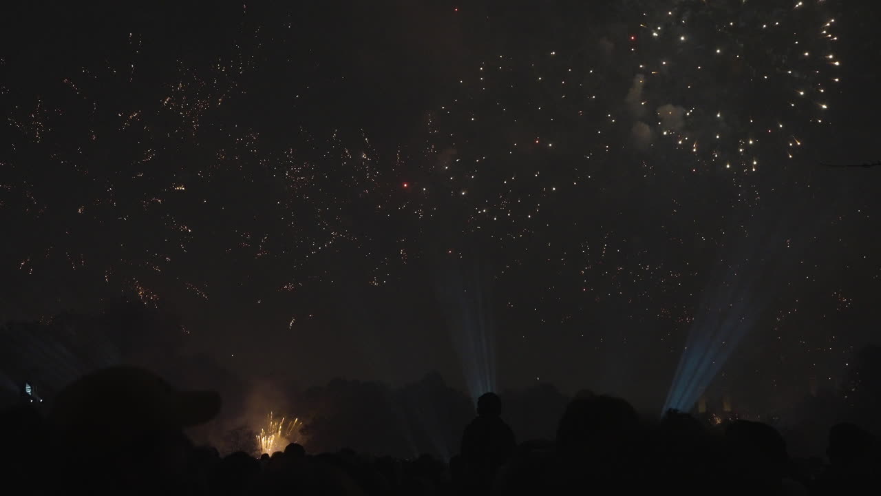Group of people capturing the bright fireworks display on film